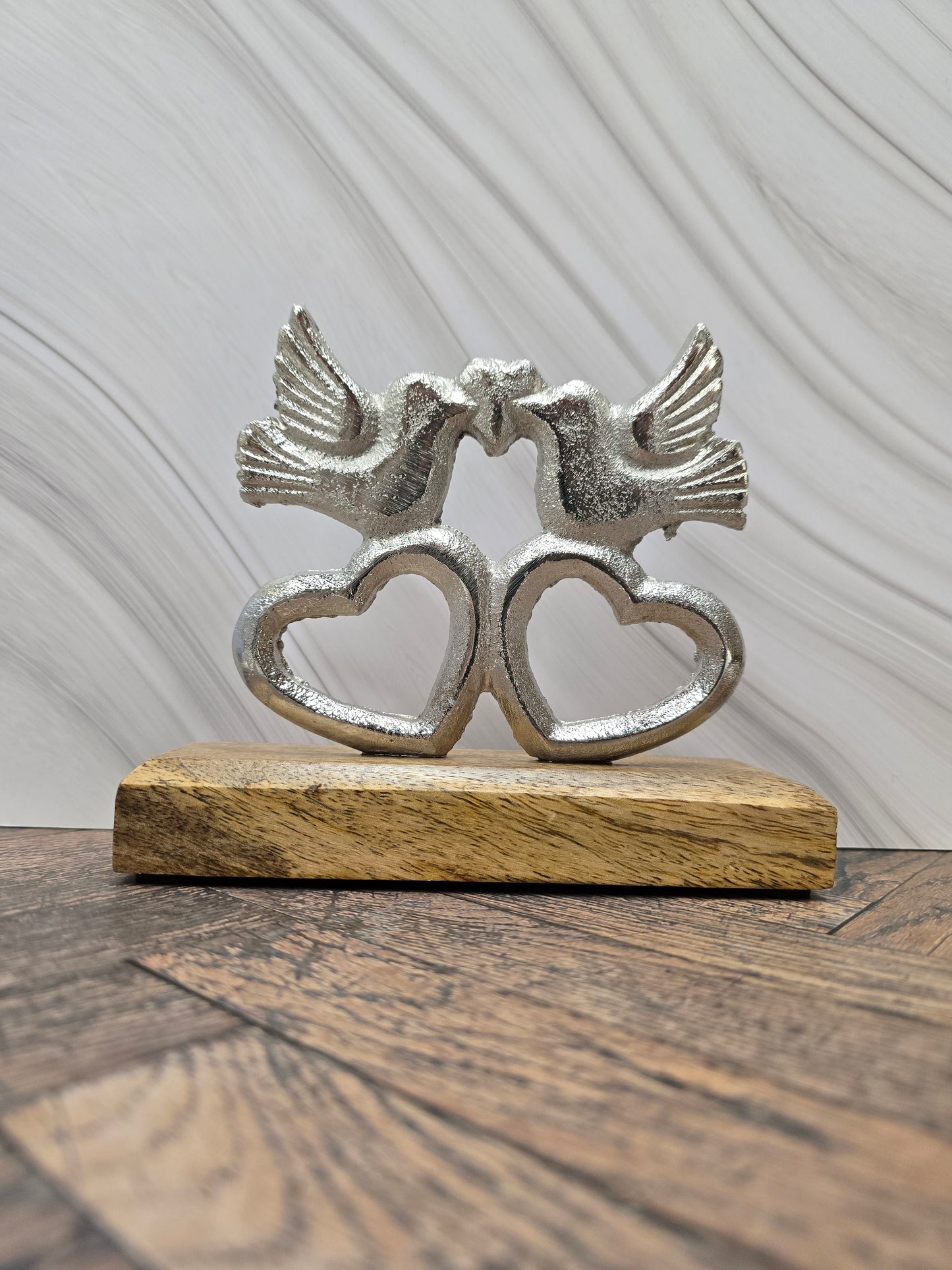 Kissing lovebirds on hearts on wooden base